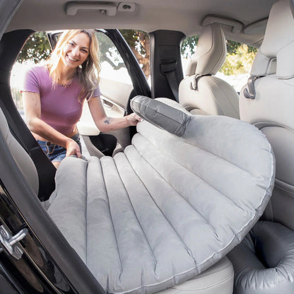 Woman setting up an inflatable car seat cover in a vehicle.